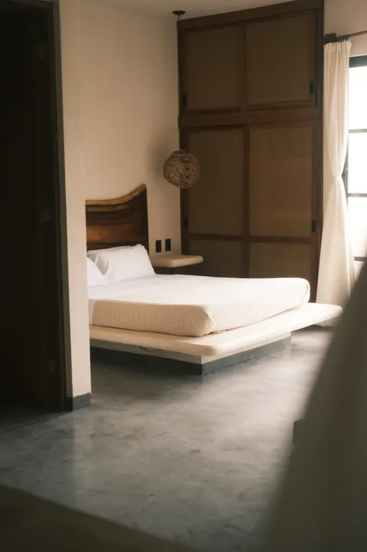 Une chambre aperçue depuis l’embrasure d’une porte en bois.