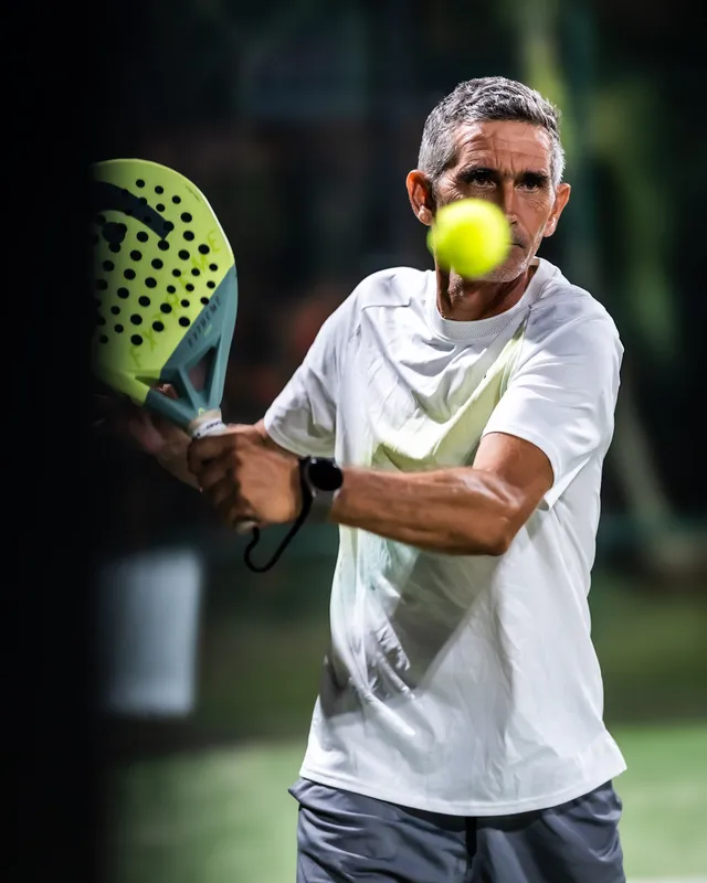 Un joueur de padel, raquette en main, les yeux fixés sur la balle.